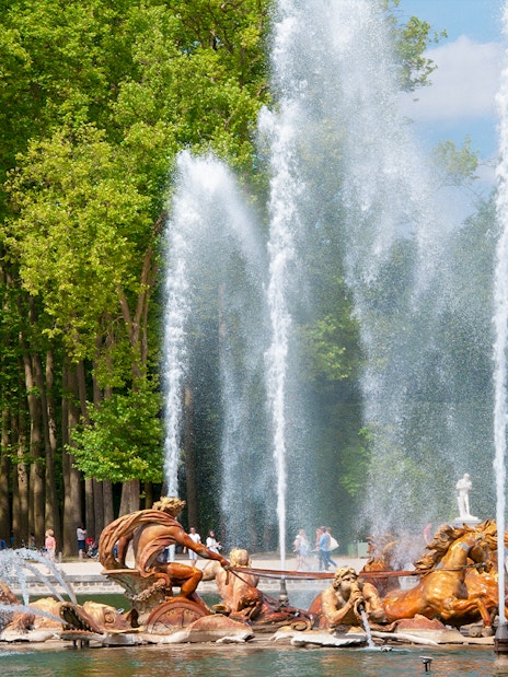 Fountain of Apollo with sculptures and water jets at Versailles Gardens, France.