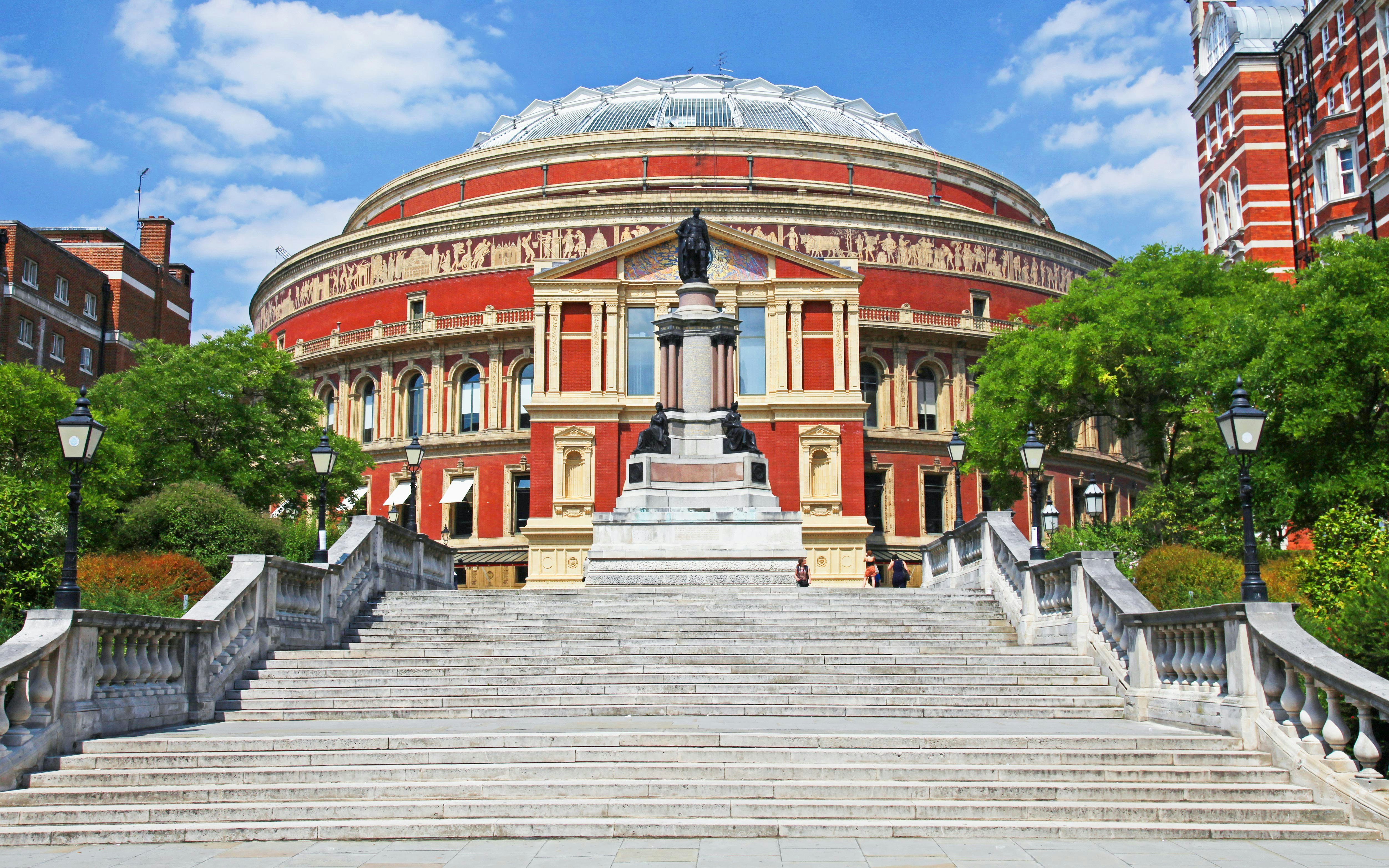 Royal Albert Hall exterior with steps and statue in London, England.