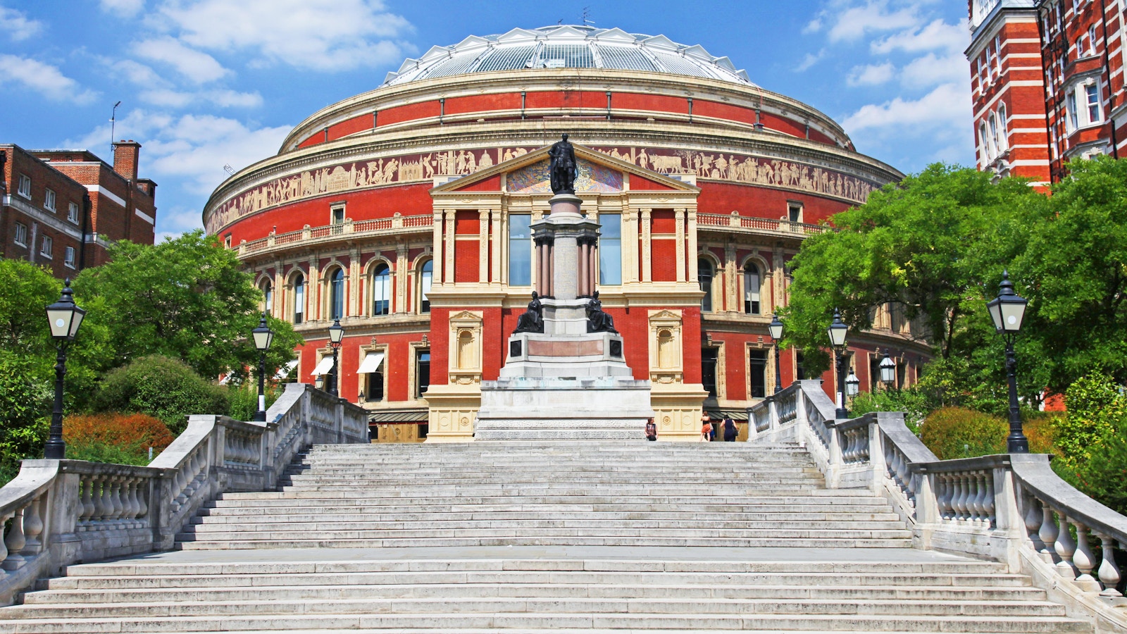 Royal Albert Hall exterior with steps and statue in London, England.