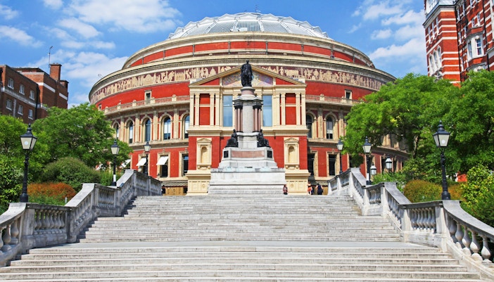 Royal Albert Hall exterior with steps and statue in London, England.