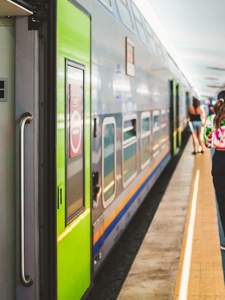 High-speed train platform in Naples with travelers and luggage.