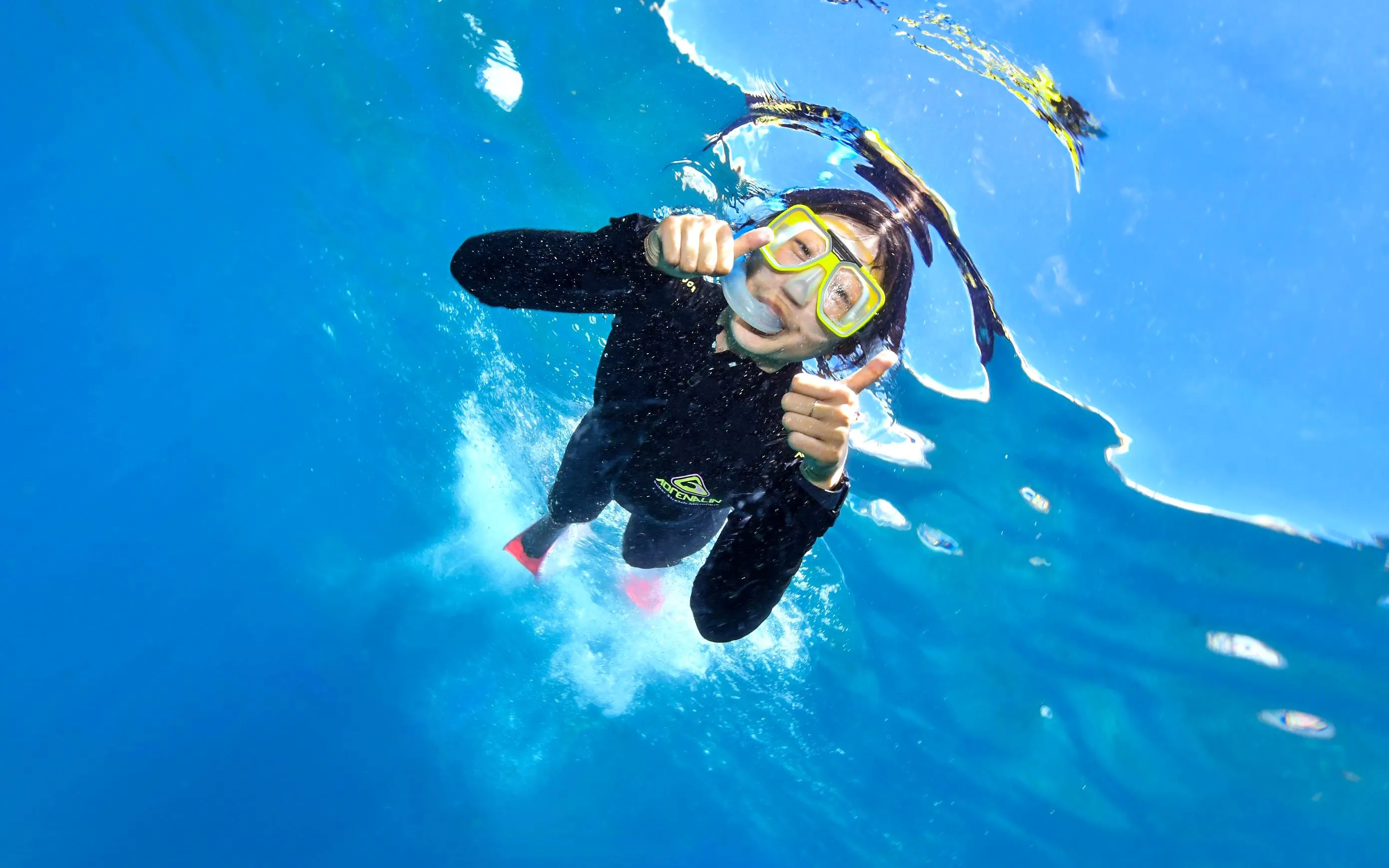 Snorkeler giving thumbs up underwater at Great Barrier Reef with Sunlover Reef Cruises.