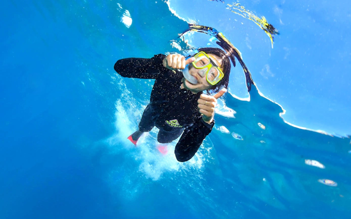 Snorkeler giving thumbs up underwater at Great Barrier Reef with Sunlover Reef Cruises.