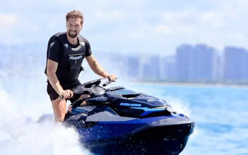 Jet skiing on blue waters with city skyline in Sanya, Beijing.