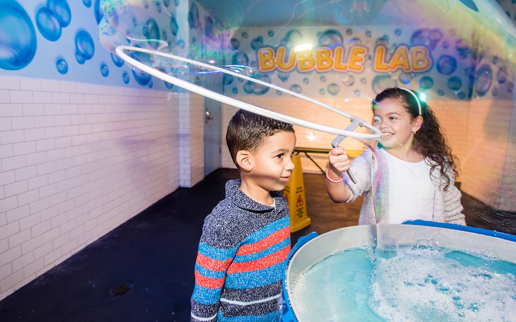 Children playing with giant bubbles at Wonderworks Bubble Lab.