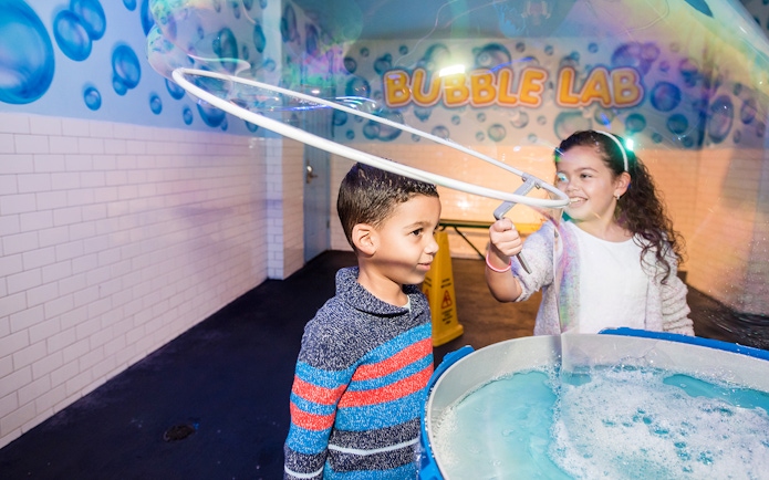 Children playing with giant bubbles at Wonderworks Bubble Lab.