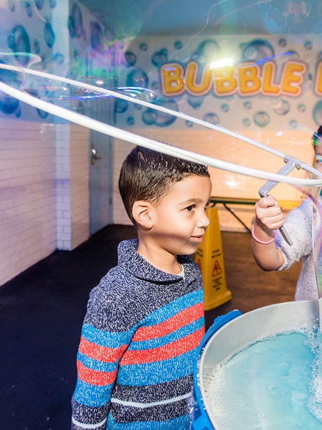 Children playing with giant bubbles at Wonderworks Bubble Lab.