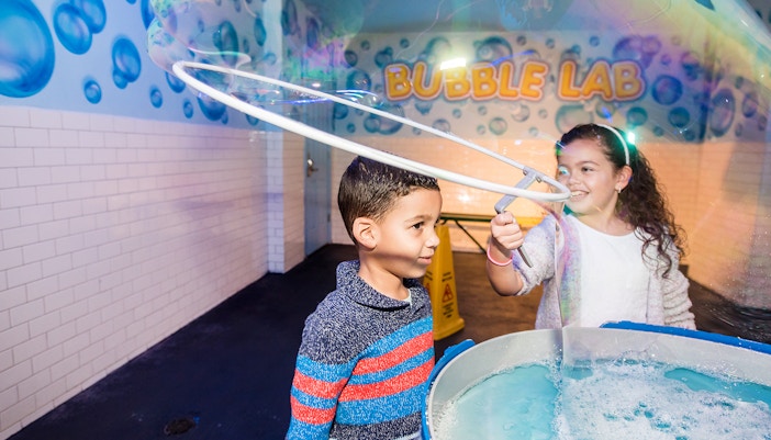 Children playing with giant bubbles at Wonderworks Bubble Lab.