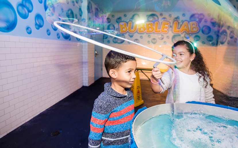 Children playing with giant bubbles at Wonderworks Bubble Lab.