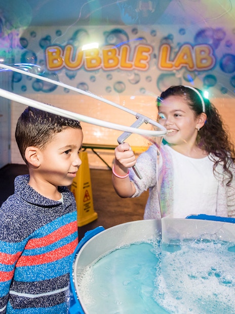 Children playing with giant bubbles at Wonderworks Bubble Lab.