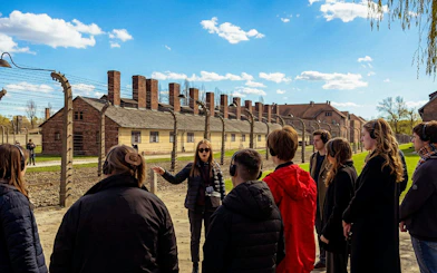 Guided tour group at Auschwitz-Birkenau State Museum grounds, Krakow.