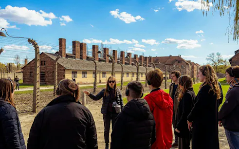 Guided tour group at Auschwitz-Birkenau State Museum grounds, Krakow.