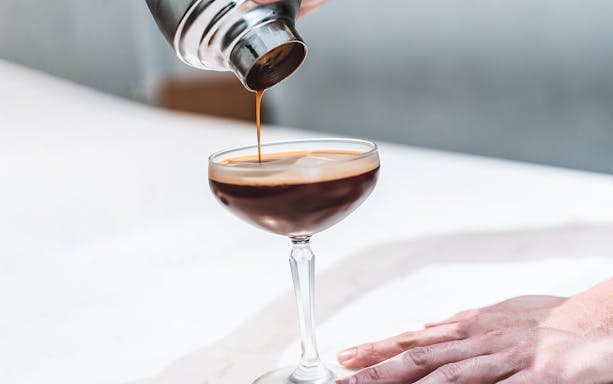 Pouring espresso martini into a glass in Kuala Lumpur.