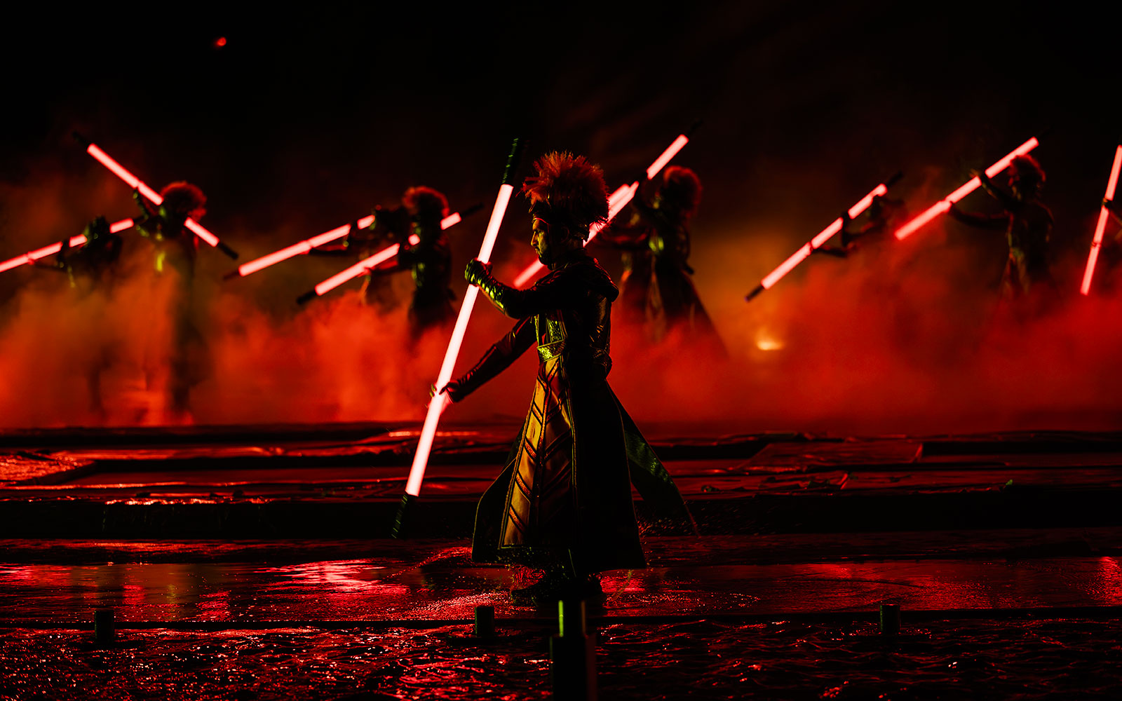 Performers with glowing red staffs in the Kiss of the Sea Show.