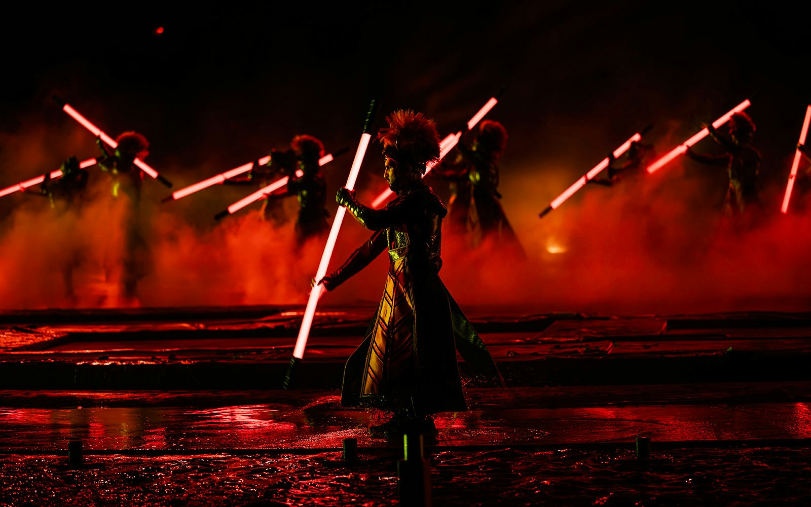 Performers with glowing red staffs in the Kiss of the Sea Show.