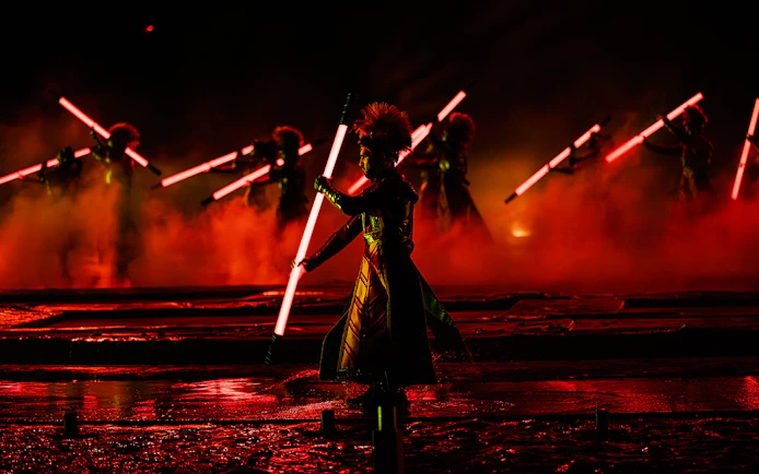 Performers with glowing red staffs in the Kiss of the Sea Show.