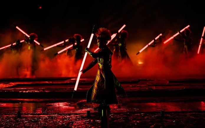 Performers with glowing red staffs in the Kiss of the Sea Show.