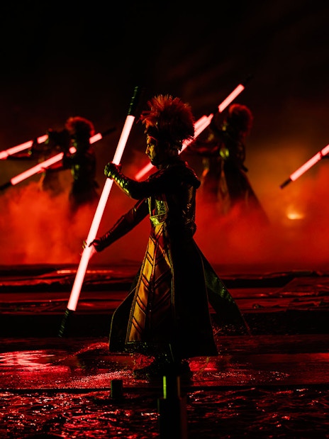 Performers with glowing red staffs in the Kiss of the Sea Show.