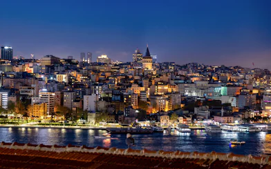 Night view of Istanbul with illuminated Galata Tower and cityscape along the Bosphorus.