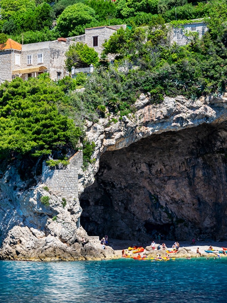 Kayakers and visitors at Betina Cave Beach, Dubrovnik, Croatia.