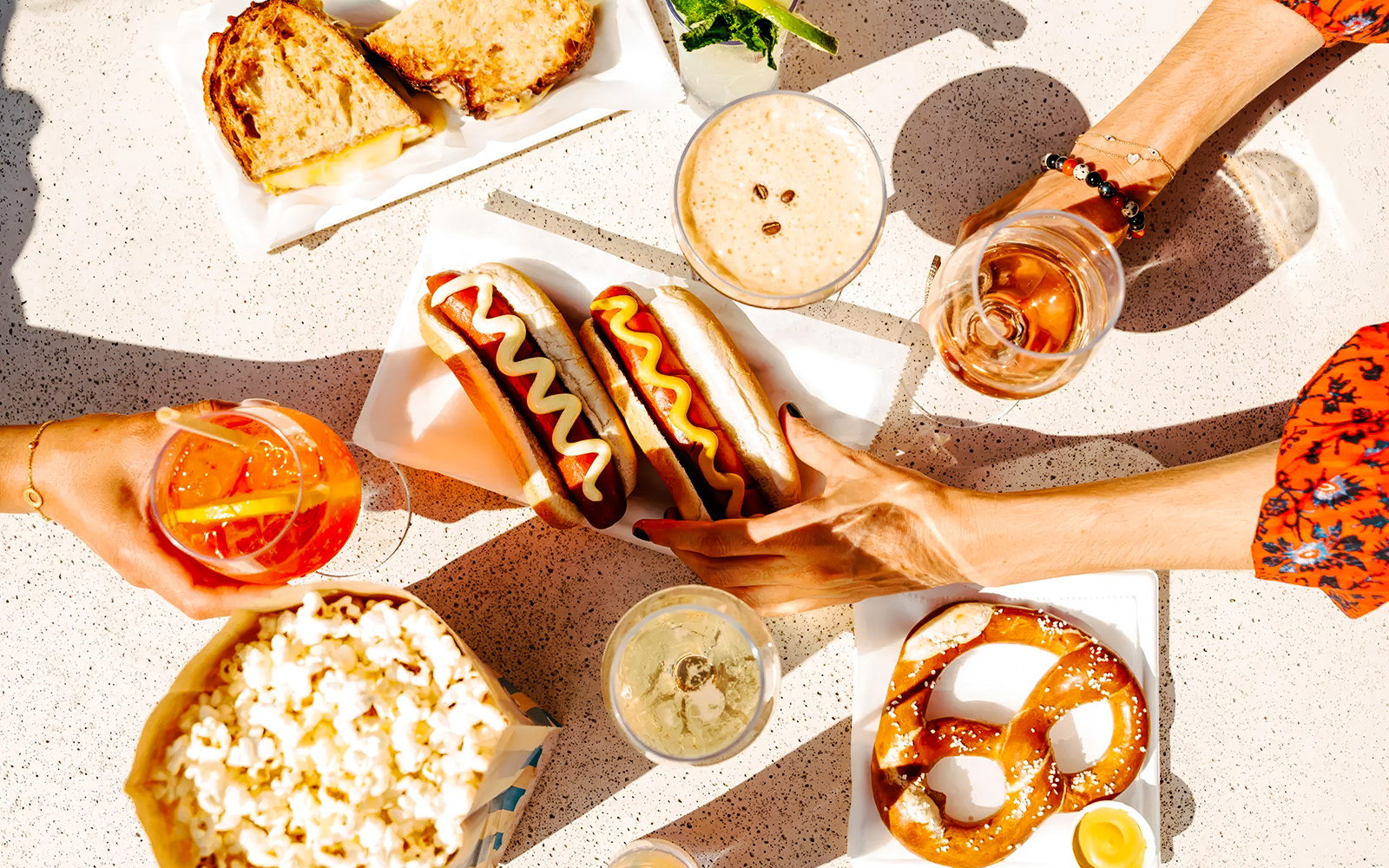 Hot dogs, pretzel, and drinks on a table at The Weather Room, Top of the Rock.