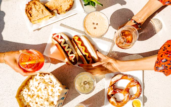 Hot dogs, pretzel, and drinks on a table at The Weather Room, Top of the Rock.