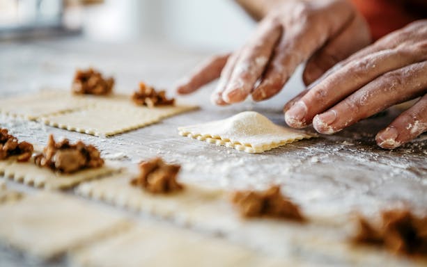 Hands preparing ravioli during a pasta cooking class in Florence.