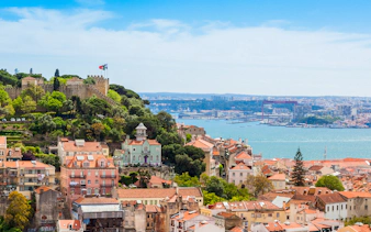 View of Lisbon rooftops and São Jorge Castle from Church of Graça terrace.
