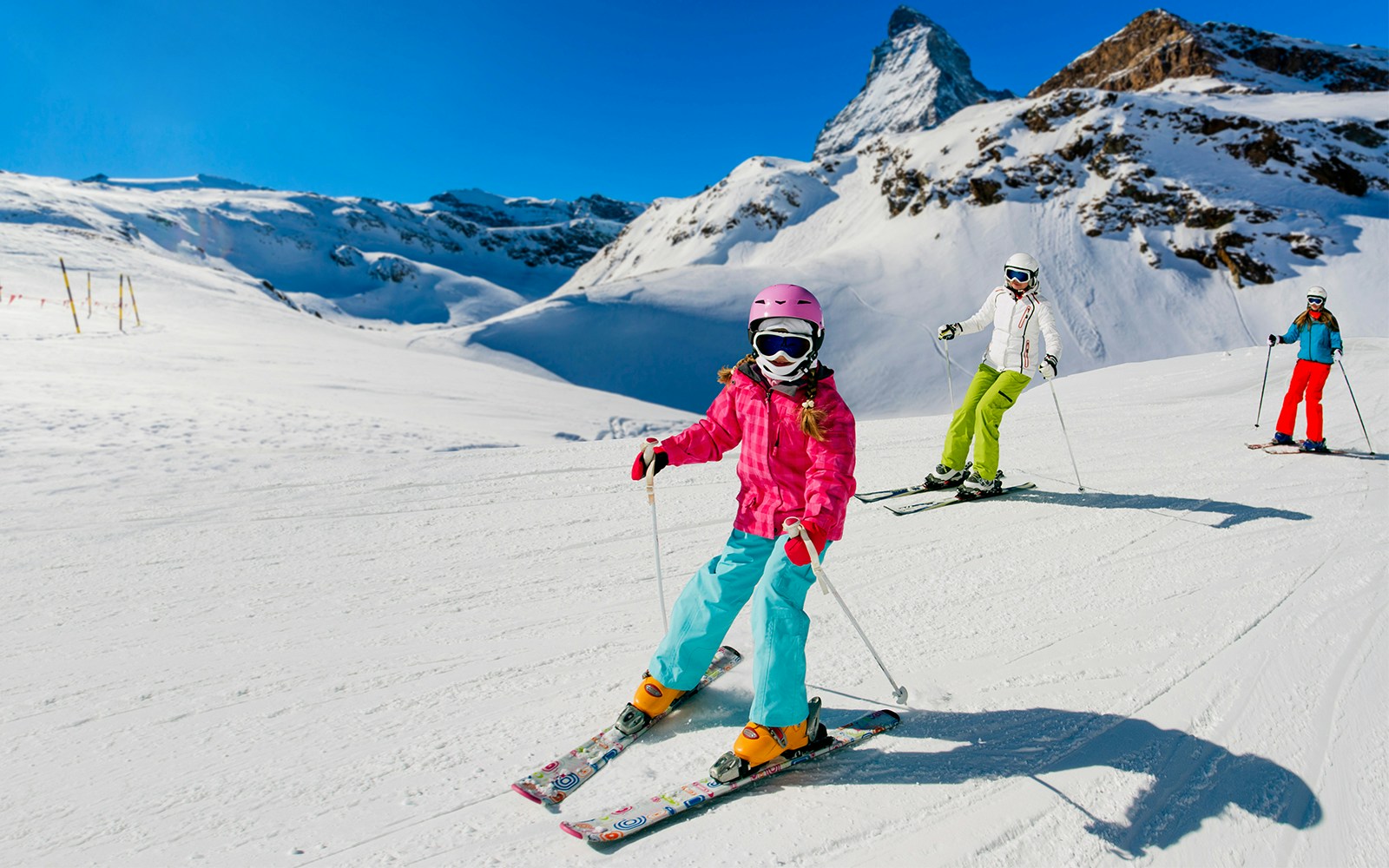 Skiers descending snowy slopes with Matterhorn in background, Gornergrat, Zermatt.