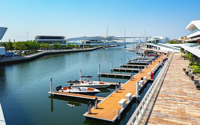 Marina view near National Aquarium Abu Dhabi with boats docked along the waterfront.