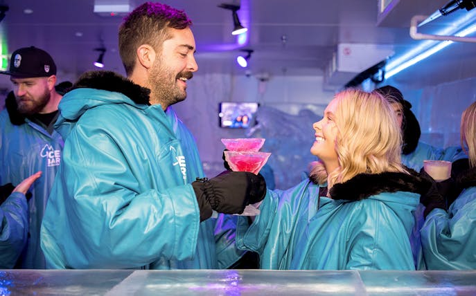 Guests enjoying drinks at IceBar Melbourne in winter coats.