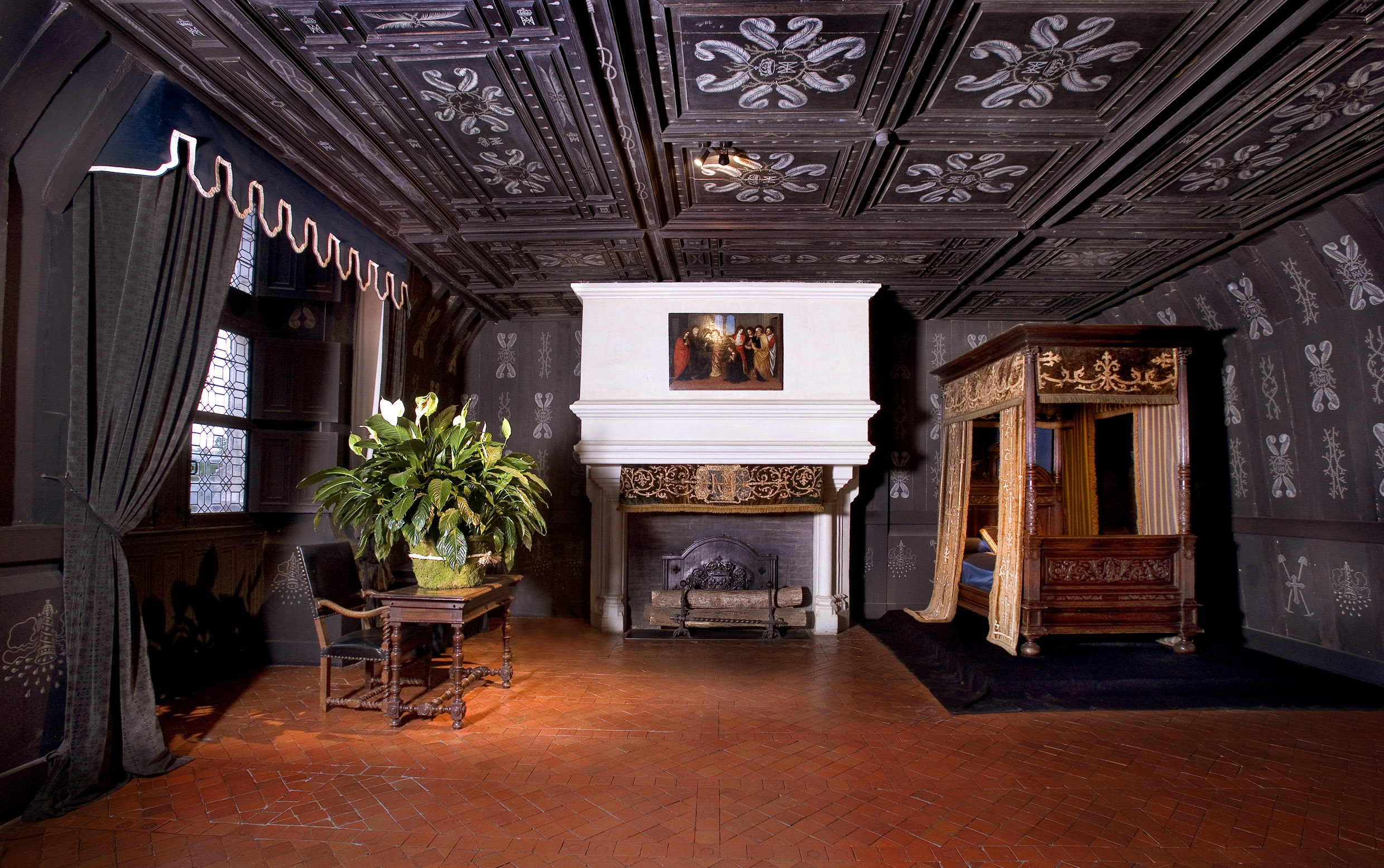 Chenonceau Castle interior with ornate fireplace and canopy bed.