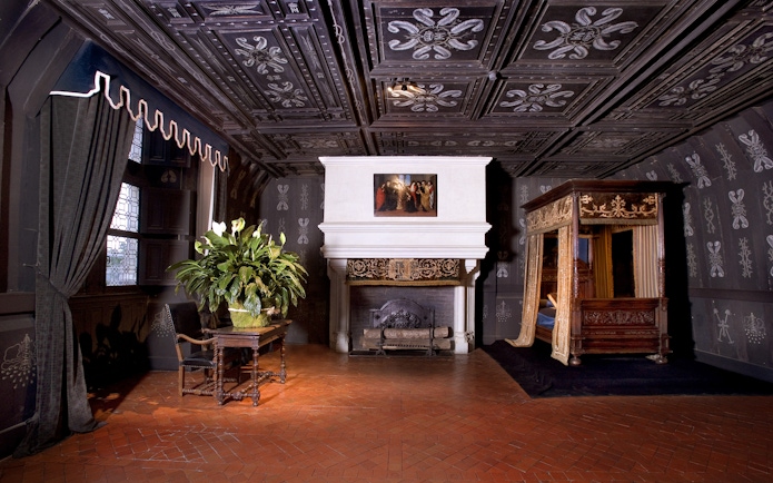 Chenonceau Castle interior with ornate fireplace and canopy bed.