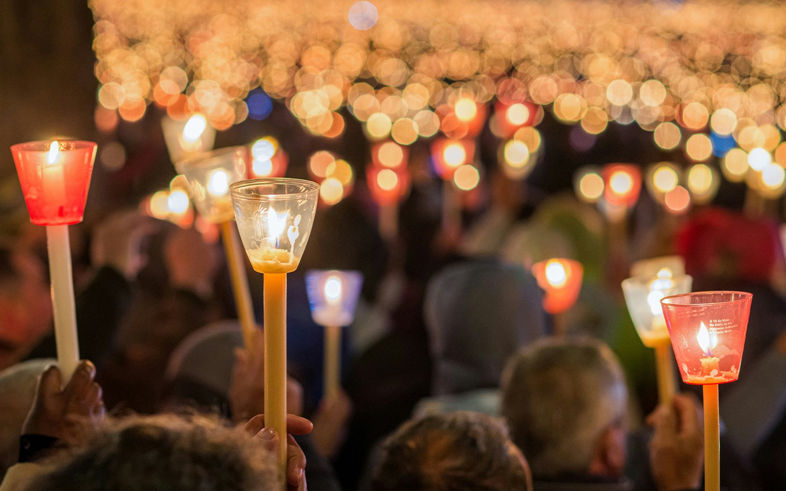 Candlelit procession through historic streets in Milan, Italy.