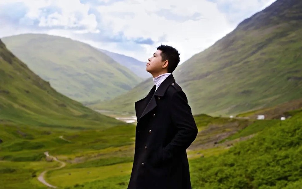 Tourist admiring the scenic valley of Glen Coe, Scotland.