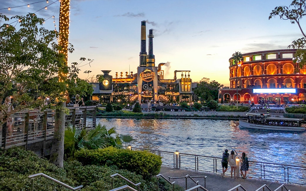 Toothsome Chocolate Emporium across the lake at sunset, Universal Orlando, Florida.