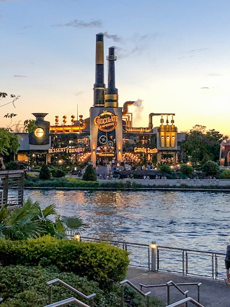 Toothsome Chocolate Emporium across the lake at sunset, Universal Orlando, Florida.