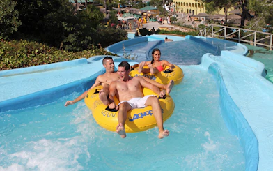 Visitors enjoying a water slide at Aquopolis Cullera's Amazon River attraction.