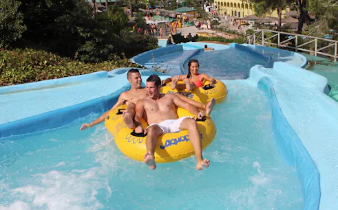 Visitors enjoying a water slide at Aquopolis Cullera's Amazon River attraction.