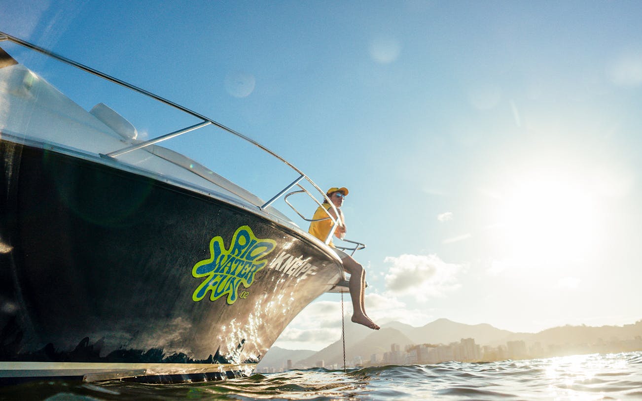 Tourist on speedboat enjoying Rio de Janeiro skyline during a sunny day.