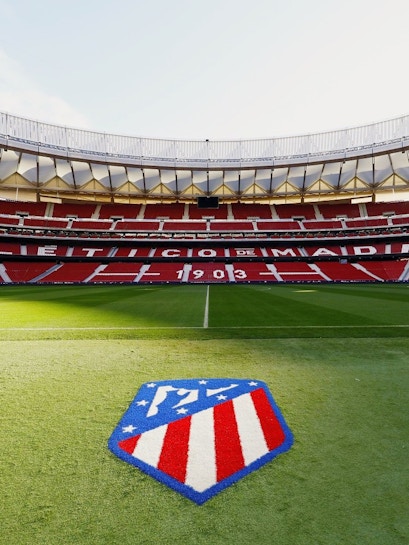Atlético de Madrid Stadium in Madrid, empty red seats and green field.
