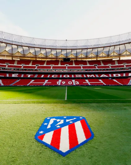 Atlético de Madrid Stadium in Madrid, empty red seats and green field.