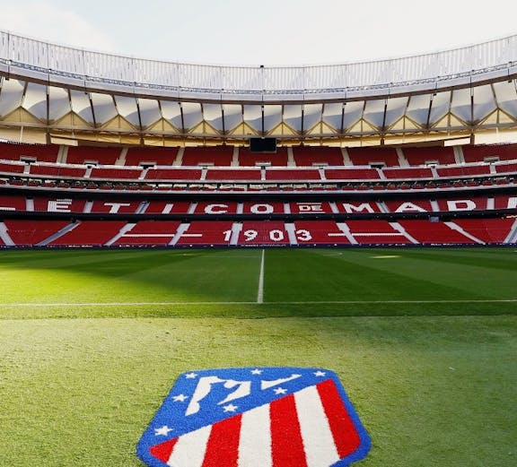 Atlético de Madrid Stadium in Madrid, empty red seats and green field.