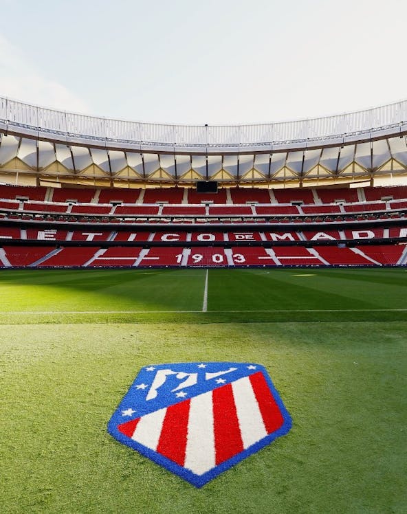 Atlético de Madrid Stadium in Madrid, empty red seats and green field.