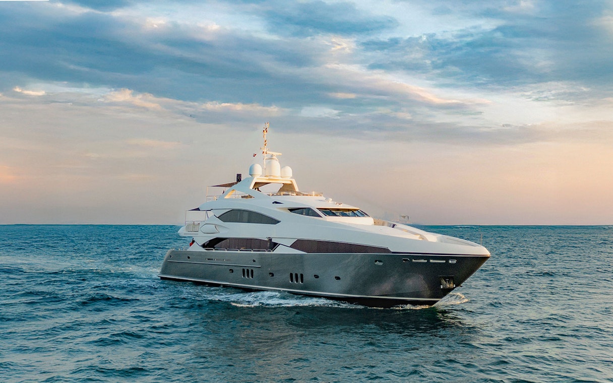 Sunseeker superyacht cruising at sunset, offering gourmet dining and live music experience.