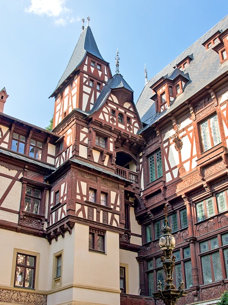 Peles Castle courtyard with intricate woodwork, Sinaia, Romania.