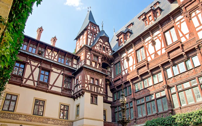 Peles Castle courtyard with intricate woodwork, Sinaia, Romania.