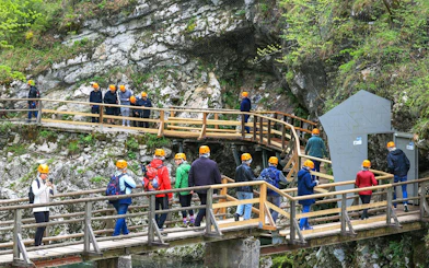 Visitors on a guided tour walking along wooden paths at Vintgar Gorge, Slovenia.