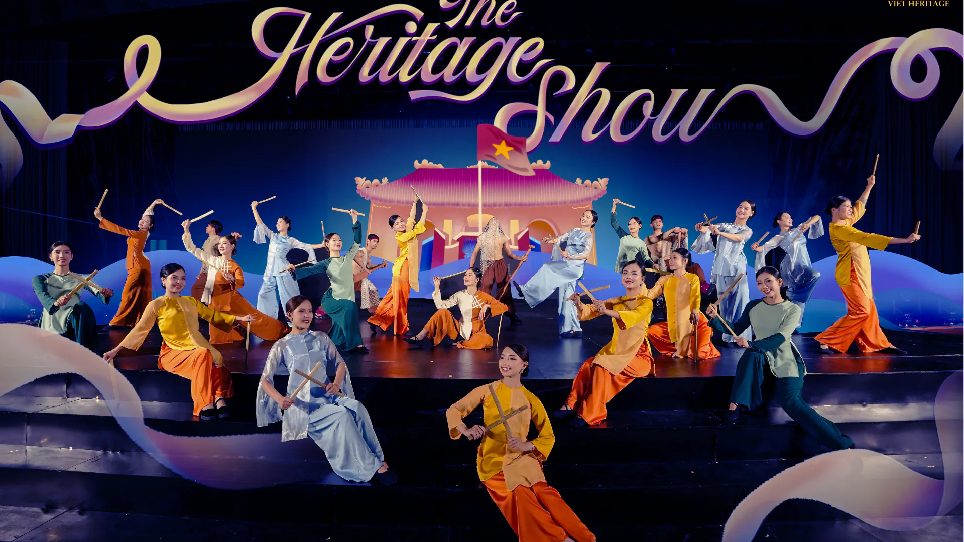 Performers in traditional attire at the Heritage Show, Da Nang, holding bamboo sticks on stage.