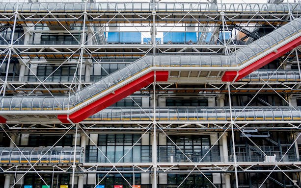 Centre Pompidou exterior with exposed structural elements and red escalator in Paris.